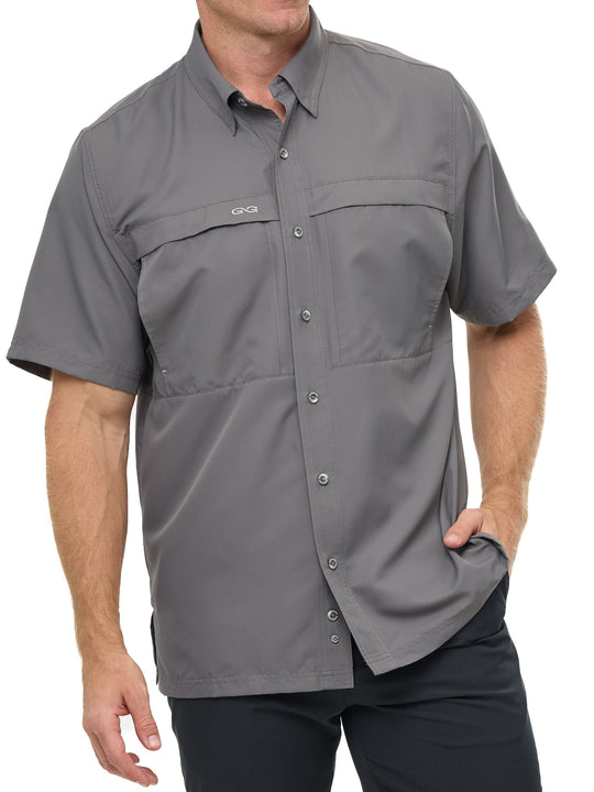 Man wearing GunMetal gray GameGuard Original short sleeve shirt with chest vents and GG logos; breathable, quick-dry performance for outdoor wear.