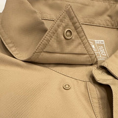 Close-up of a Khaki Original Shirt with button details and a brand label.